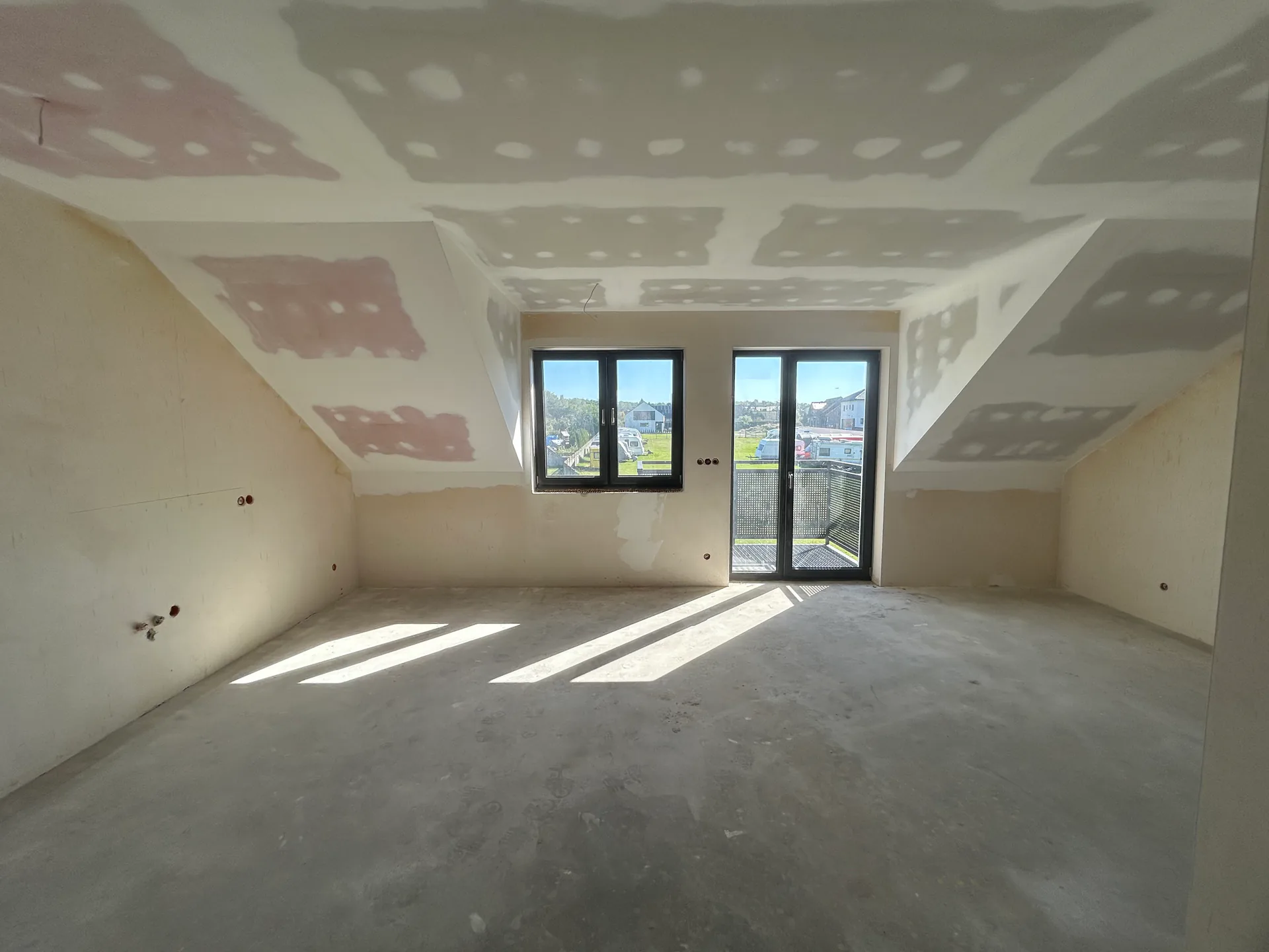 Huberta Ratki — główne pomieszczenie lokalu na poddaszu ze skosami, oknem i wyjściem na balkon